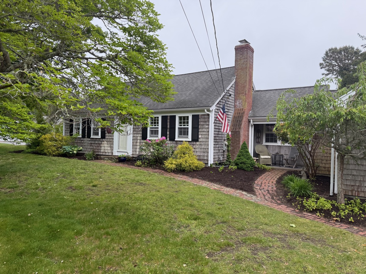 Side exterior with brick walkway and American flag